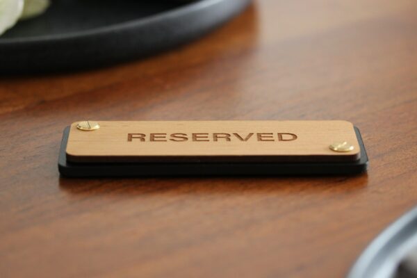 Schild für Tischreservierung im Restaurant aus Leder mit Holz und Aufschrift: RESERVED.