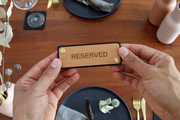 Schild für Tischreservierung im Restaurant aus Leder mit Holz und Aufschrift: RESERVED.