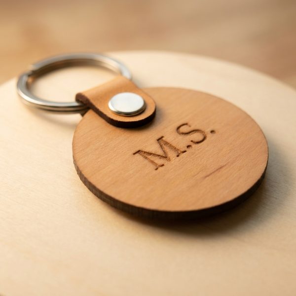 Nahaufnahme Schlüsselanhänger aus Erlenholz mit personalisierter Gravur und Lederlasche